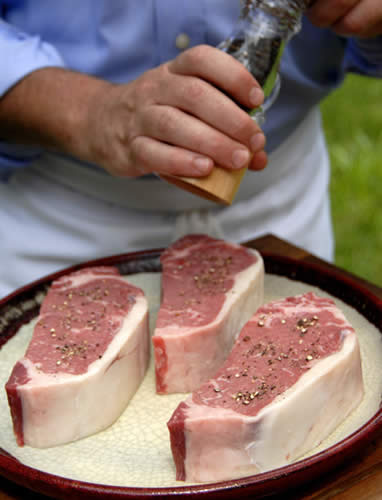 Sprinkling pepper on the steak